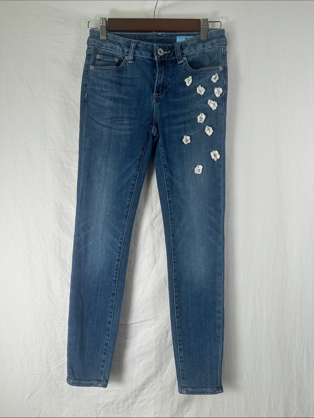 CeCe Blue Skinny Jeans with White Floral Appliqués